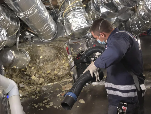Westwood Air Duct Cleaning specialist operating negative pressure cleaning equipment for thorough duct maintenance in Westwood